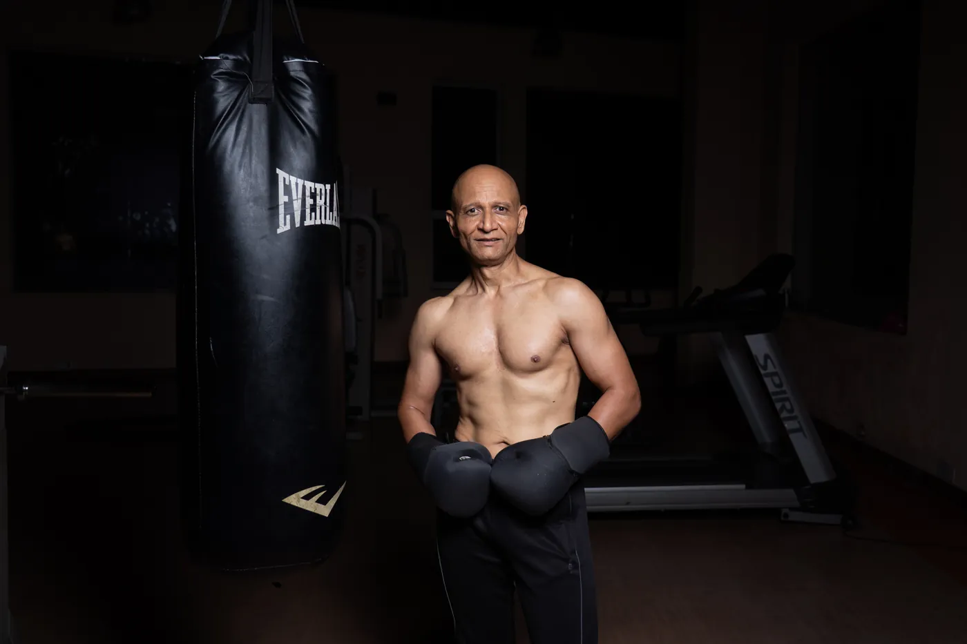 Ajay Pal Singh with boxing gloves beside a heavy bag